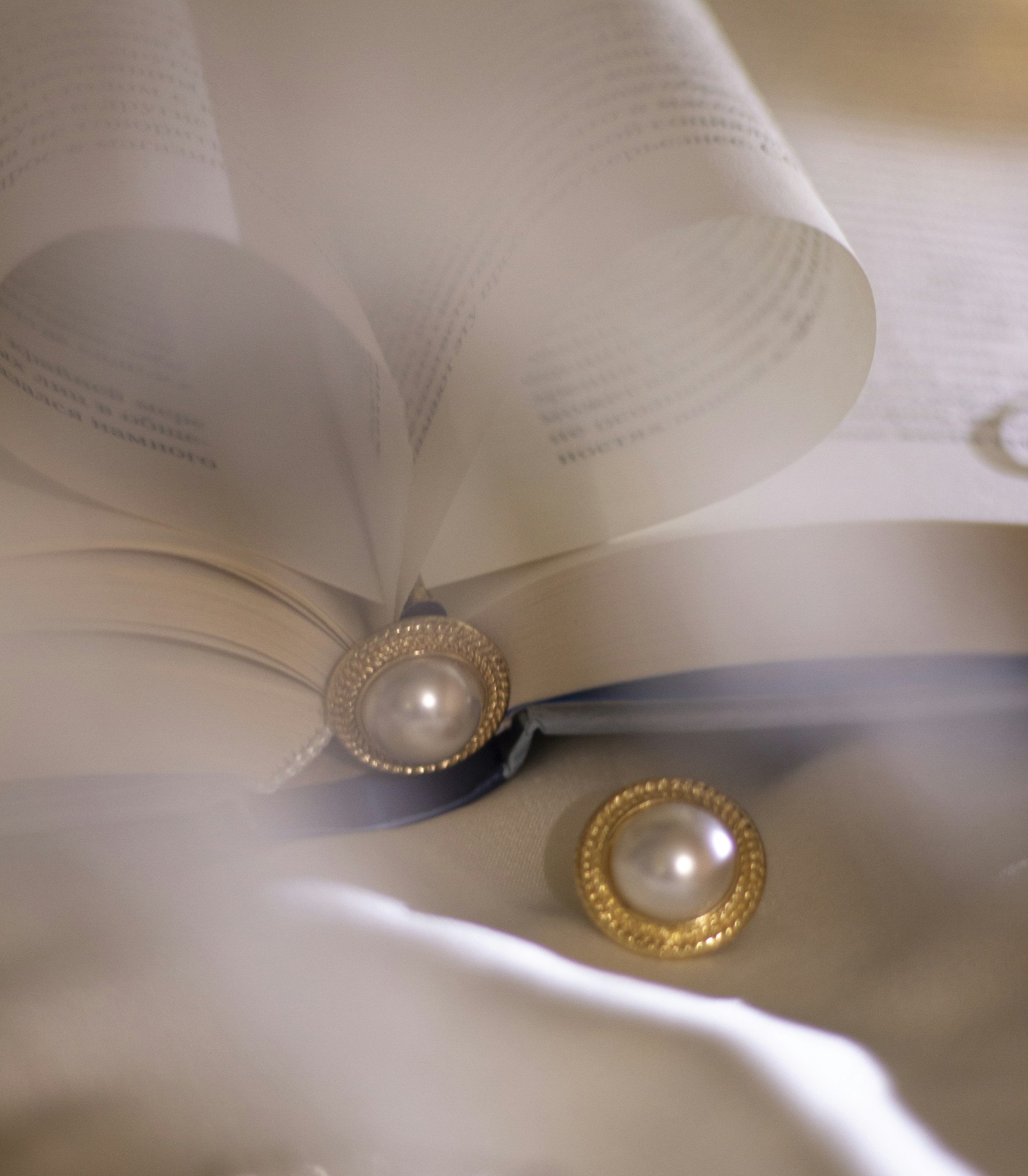 gold round analog watch on white paper