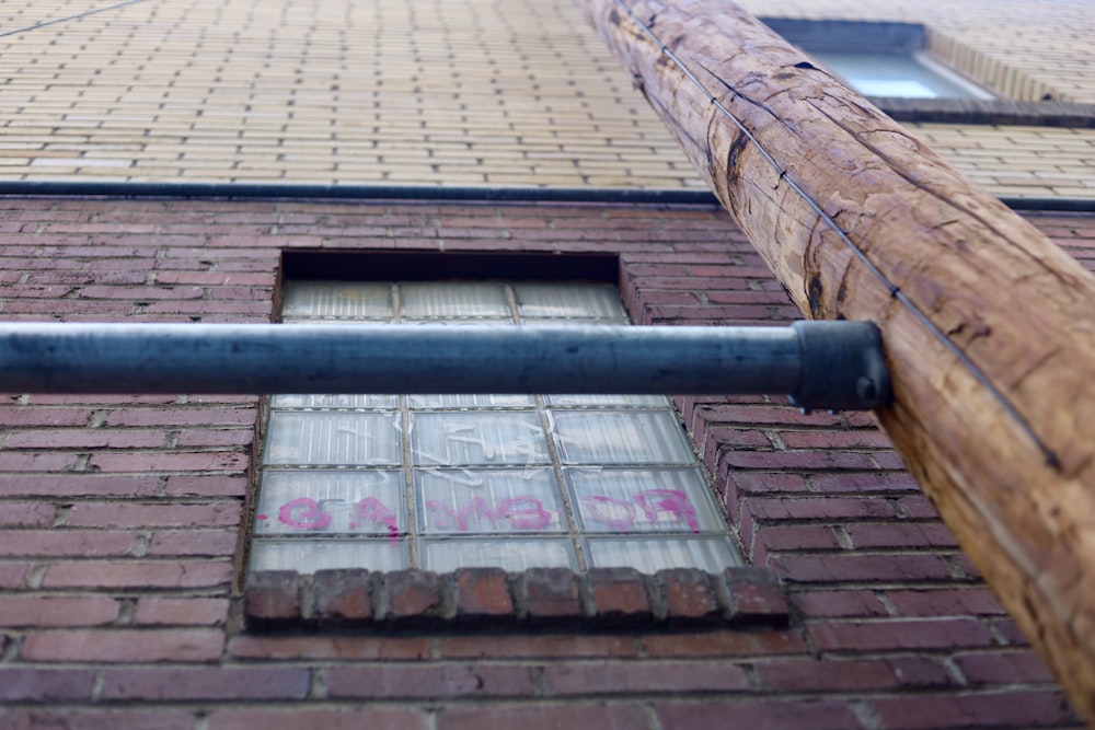 black metal pipe on brown brick wall