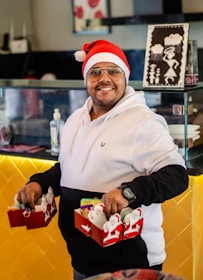 man in white nike hoodie holding red and white plastic toy car