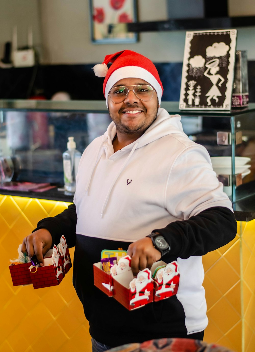 man in white nike hoodie holding red and white plastic toy car