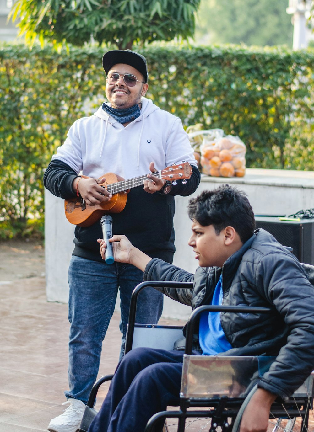 man in blue jacket playing brown acoustic guitar