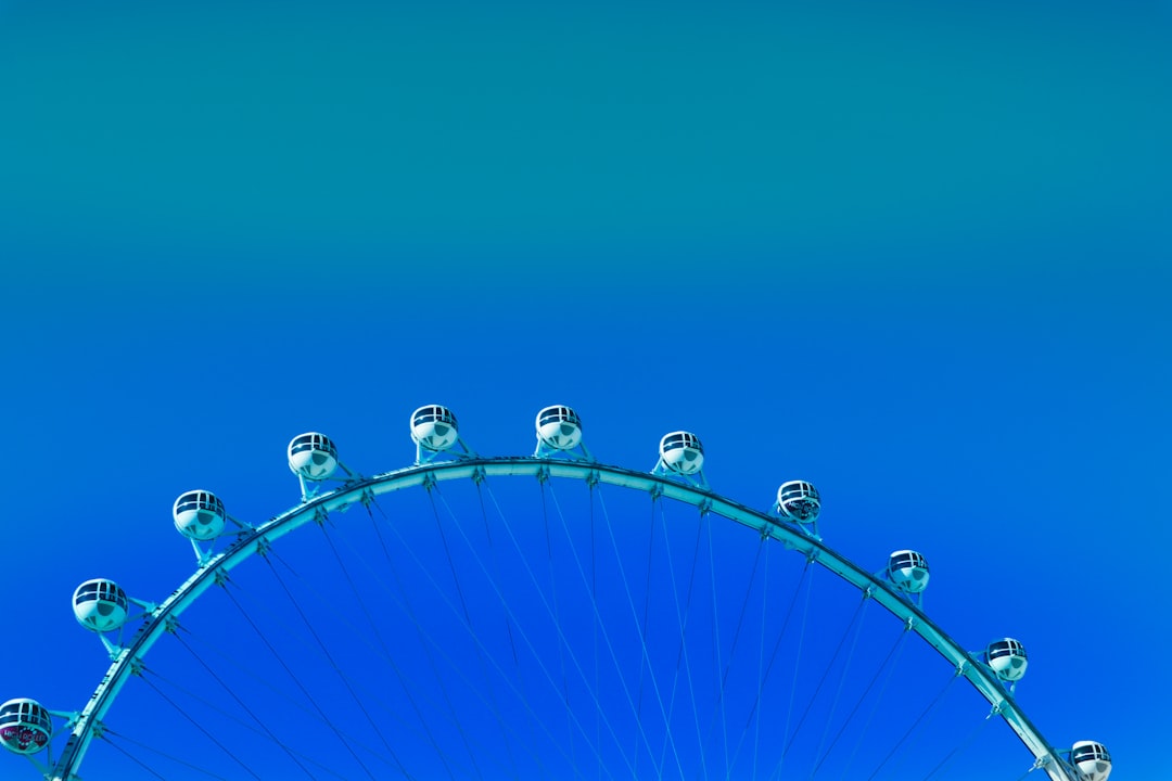 blue and white ferris wheel under blue sky during daytime,