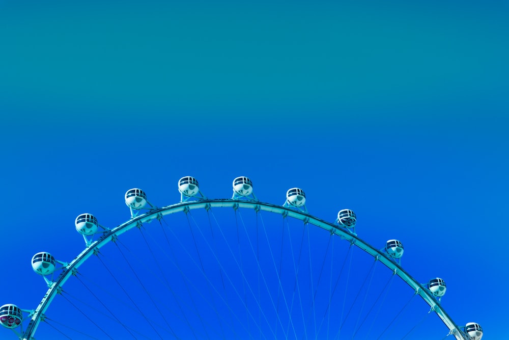 blue and white ferris wheel under blue sky during daytime