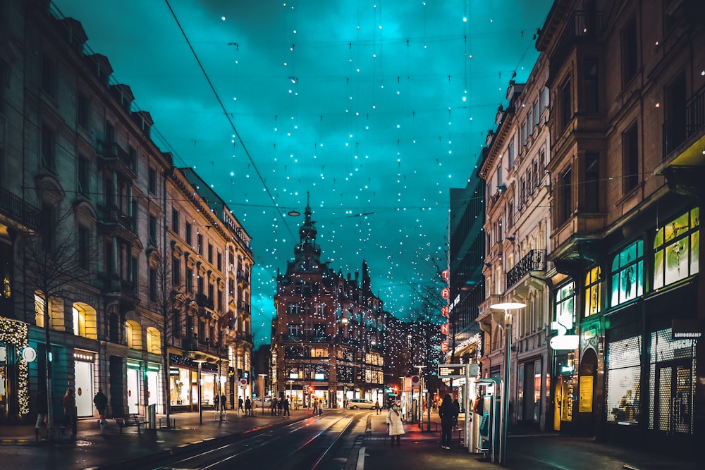 cars on road between buildings during night time