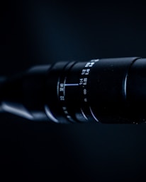 Close-up of a professional camera lens focusing on a subject.