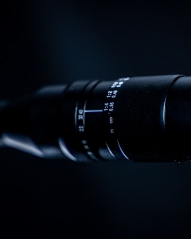 Close-up of a professional camera lens focusing on a subject.