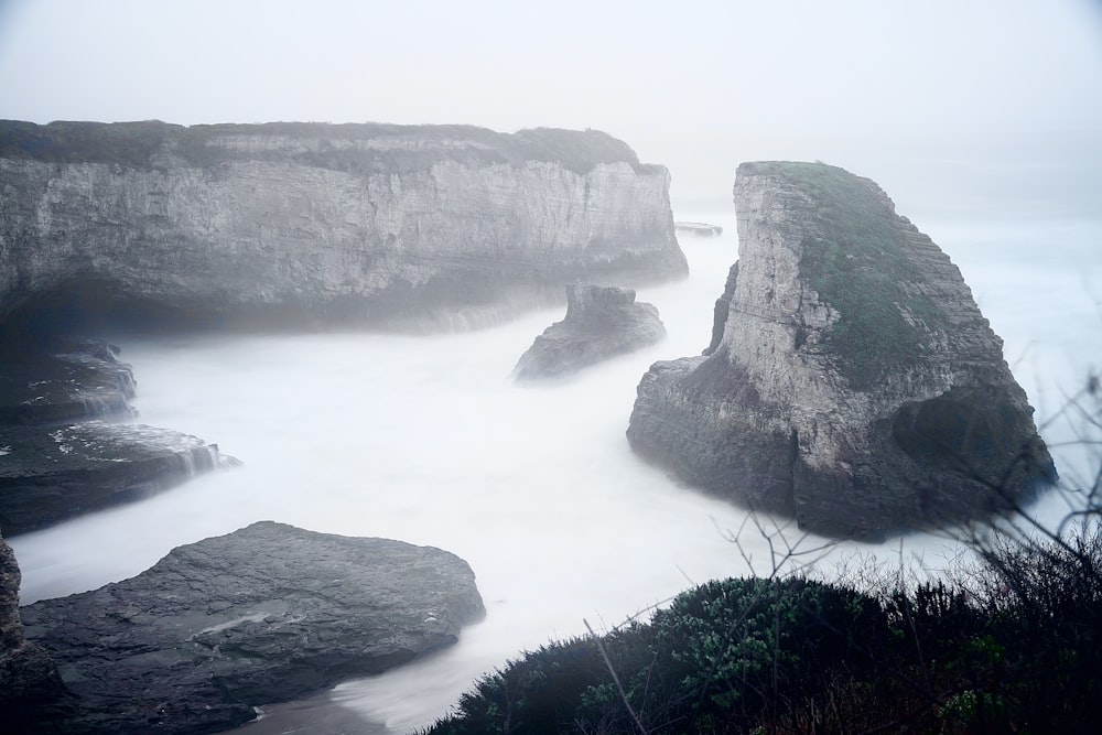 brown rock formation on body of water during daytime