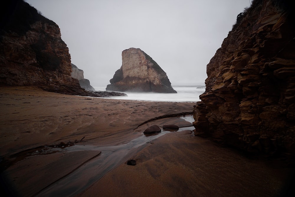 brown rock formation near body of water during daytime