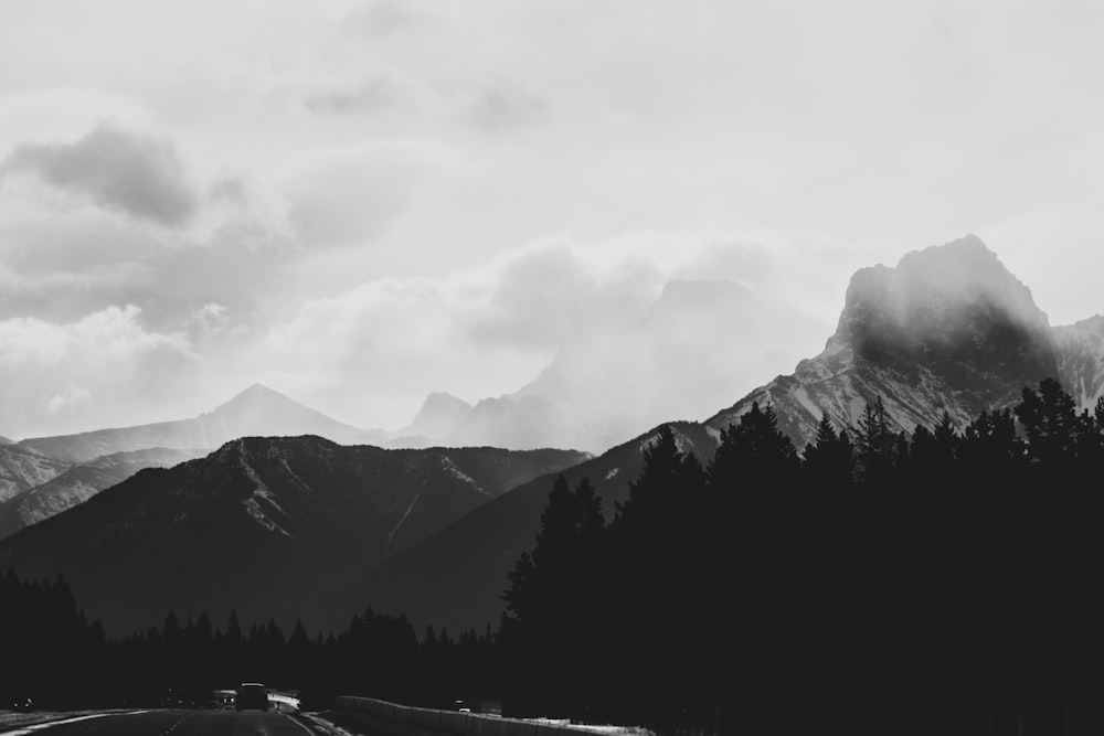 grayscale photo of mountains and trees