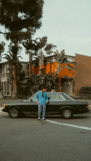 Friendly team member handing cash to a happy customer beside a junk car in Miami Beach.