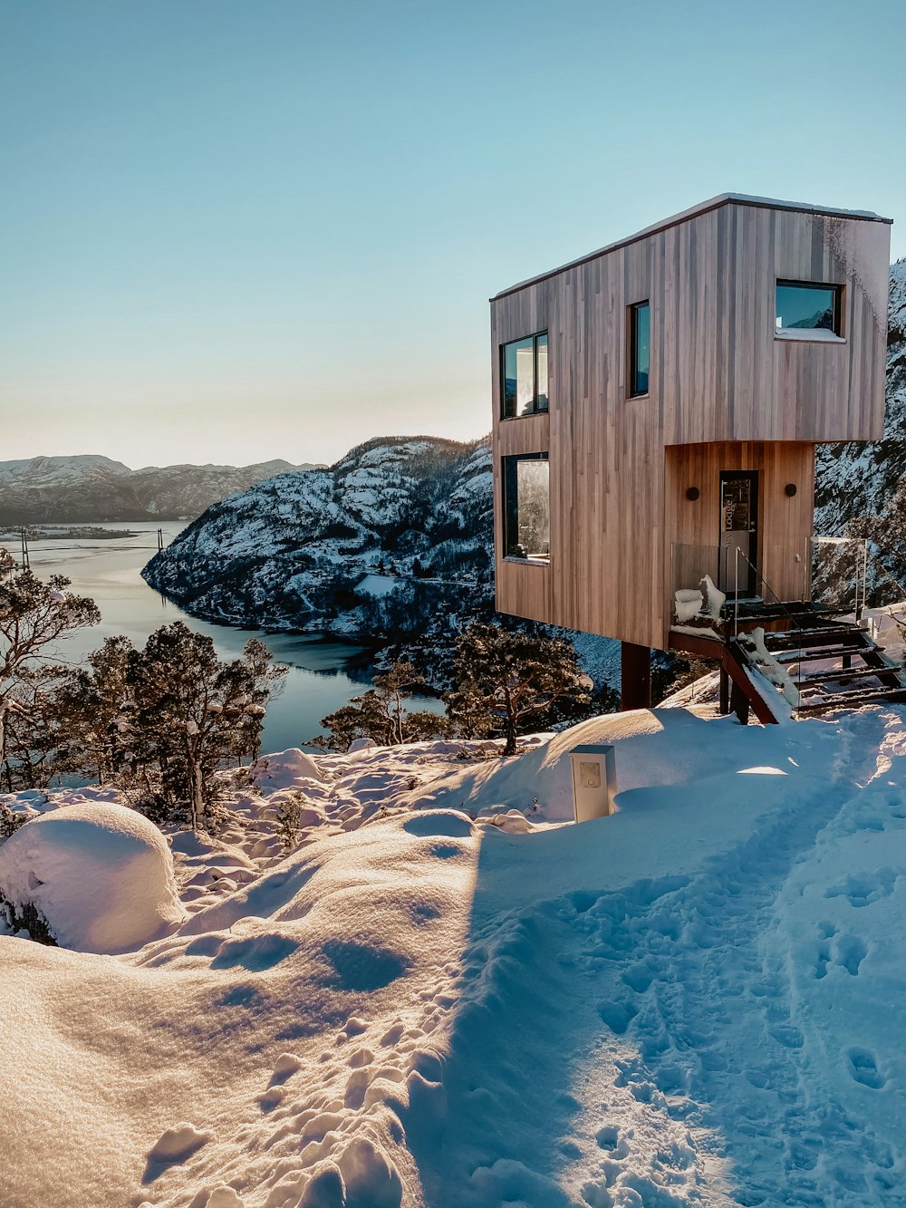 brown wooden house on snow covered ground during daytime