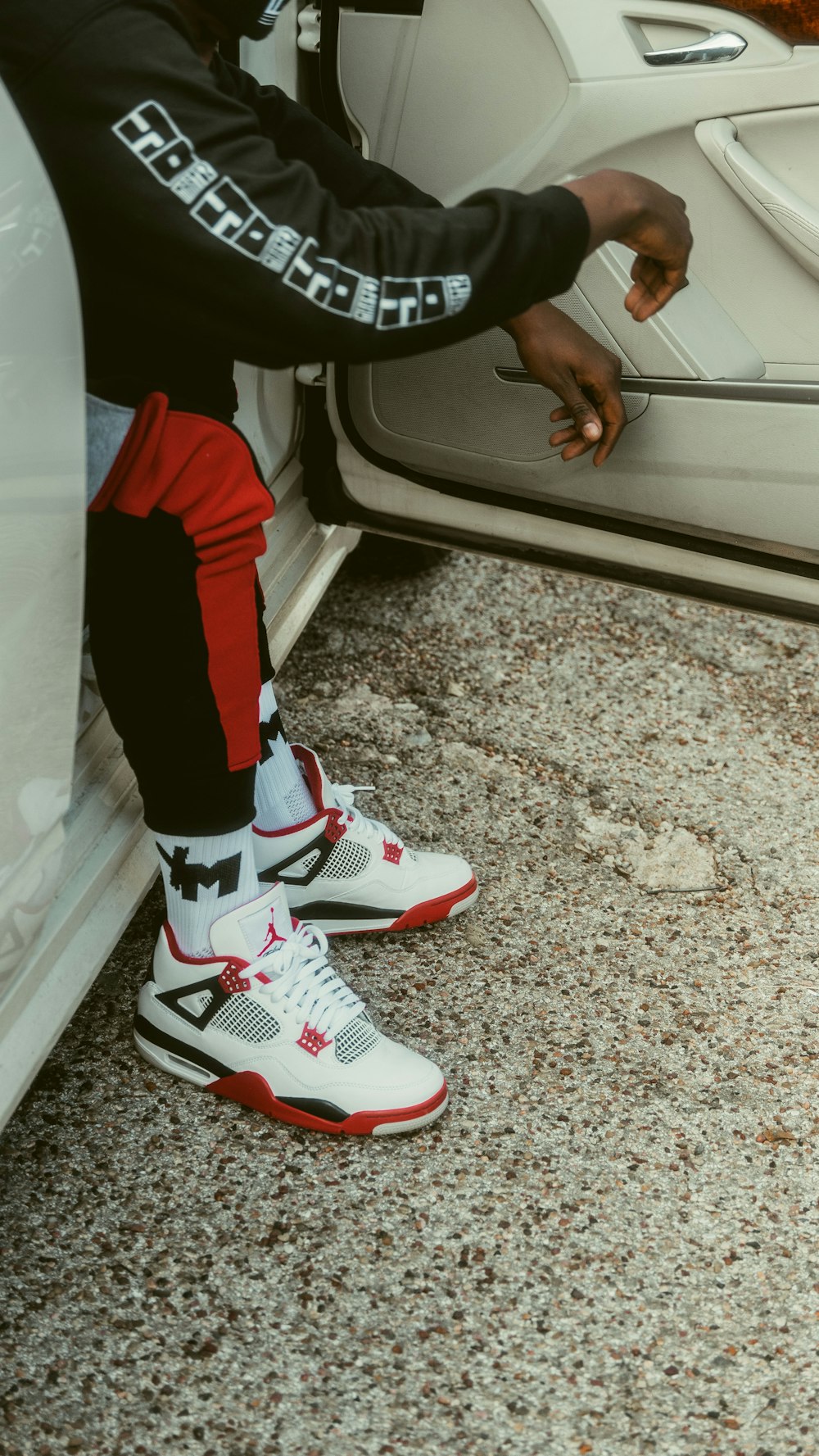 person in red pants and white and red nike sneakers