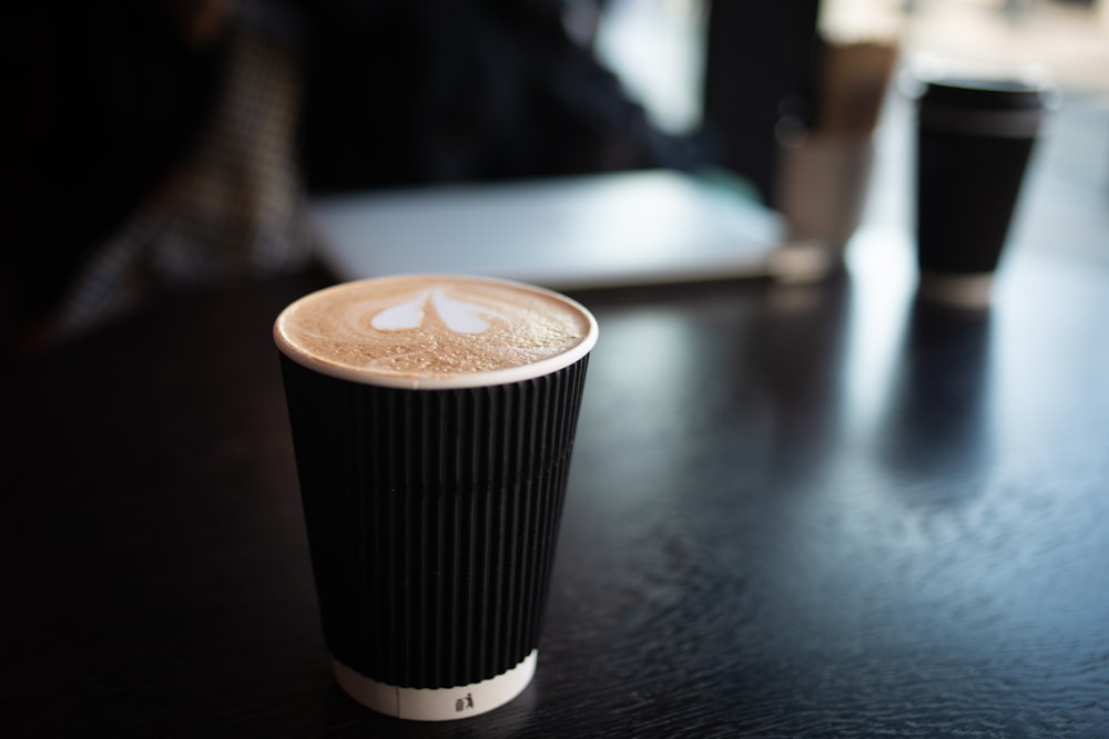 black and white coffee cup on black table