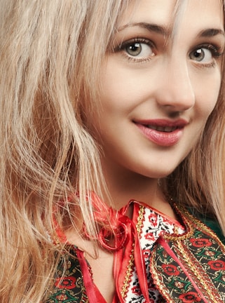 A smiling customer wearing a beautifully embroidered hair bow in natural light.