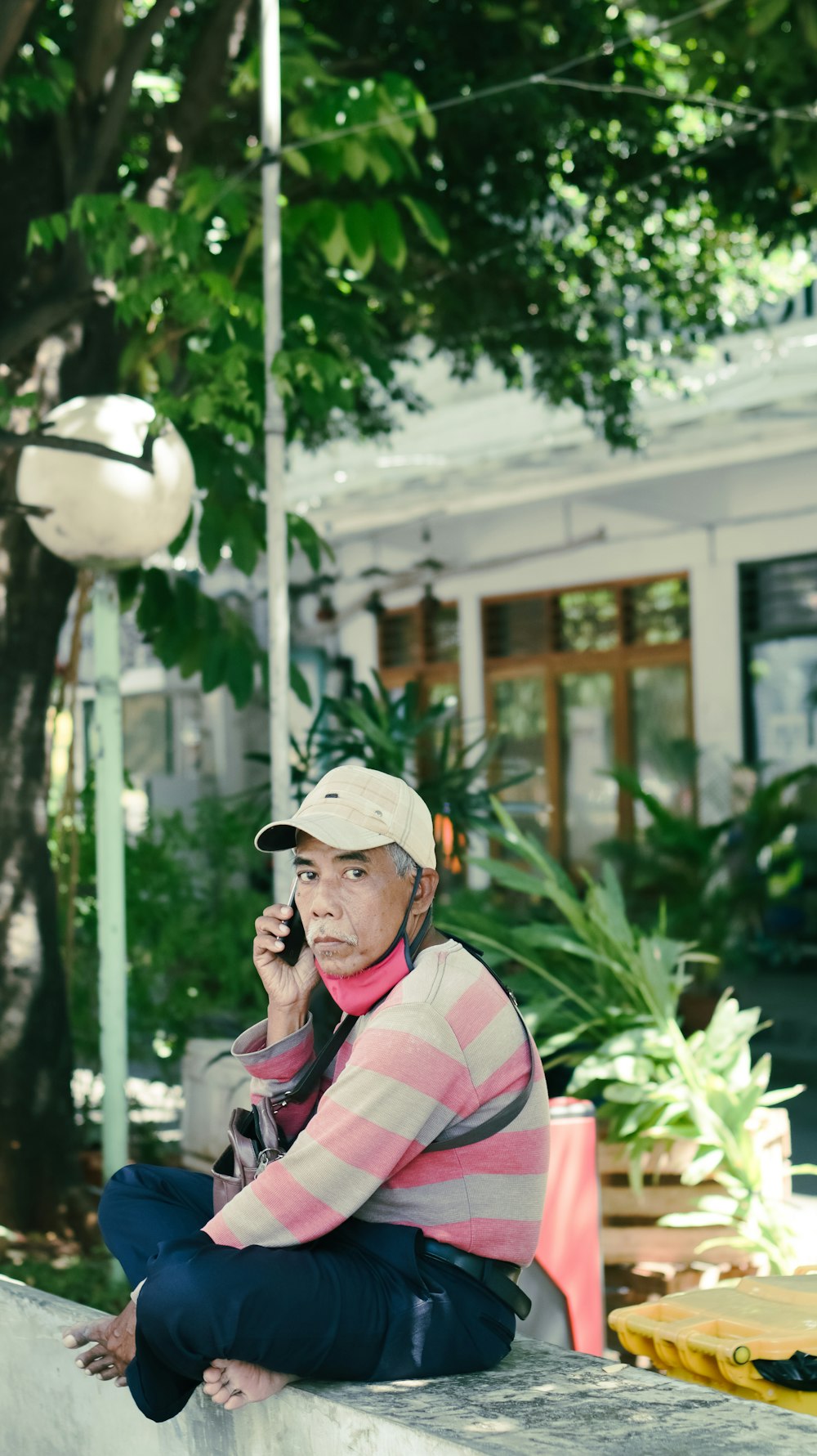 man in pink and white stripe long sleeve shirt wearing white hat