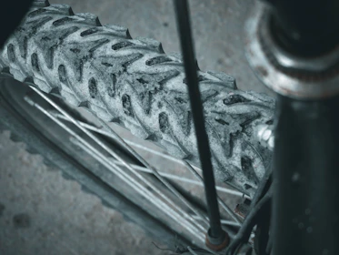 Close-up of a gravel bike tire kicking up dust along a rugged path.