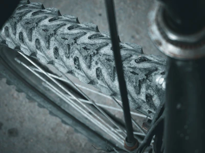 Close-up of a gravel bike tire gripping a rugged dirt path with mountains in the background.