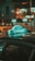A taxi roof sign with the word 'CHAMP' is prominently displayed against a blurred urban nighttime background. The sign is illuminated and casts a reflection on the car roof, surrounded by bokeh lights in the background, creating a vibrant and dynamic scene.