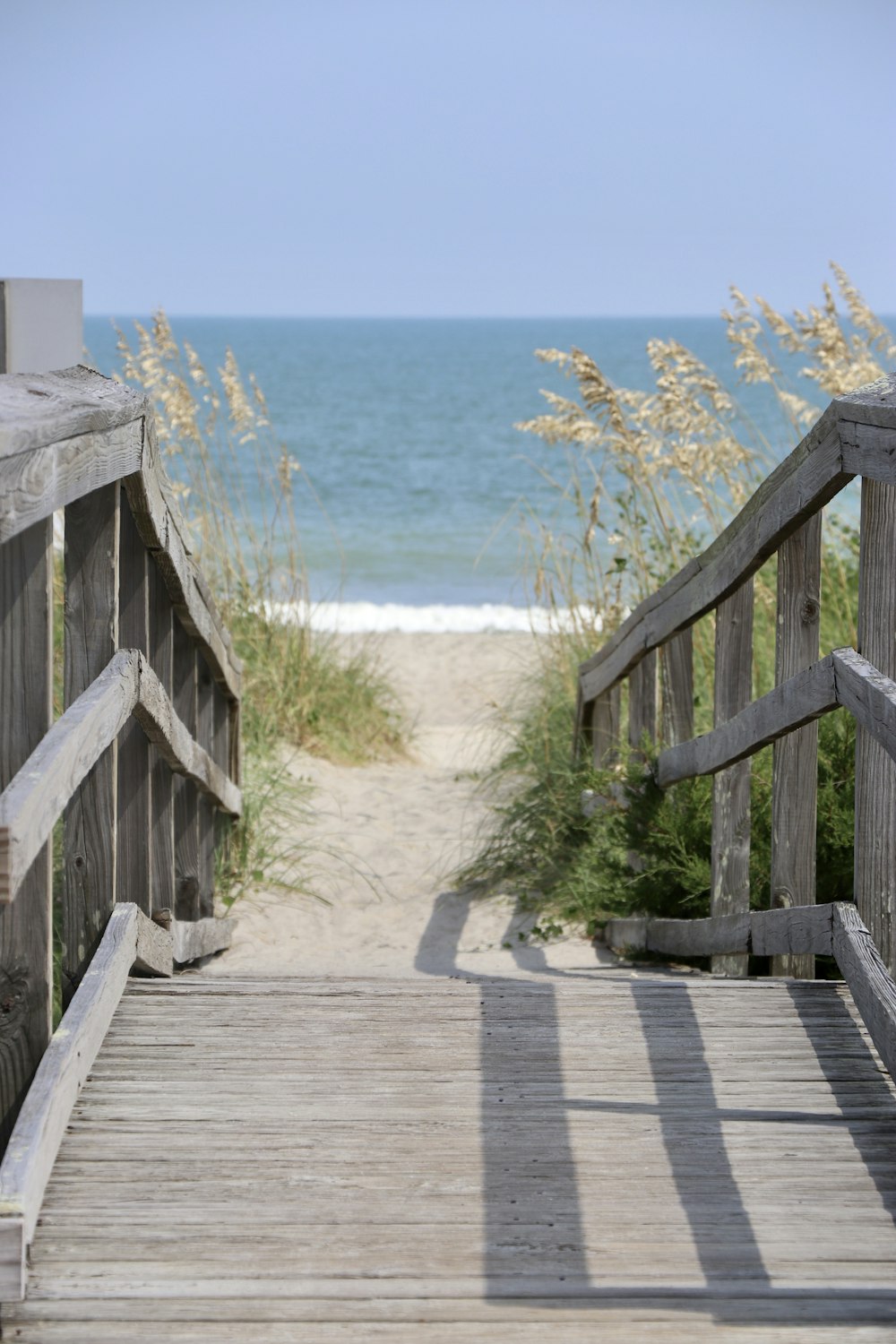 brown wooden bridge over blue sea during daytime