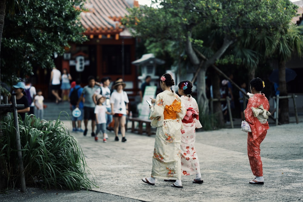 Mujer en kimono floral blanco y rojo caminando en la calle durante el día