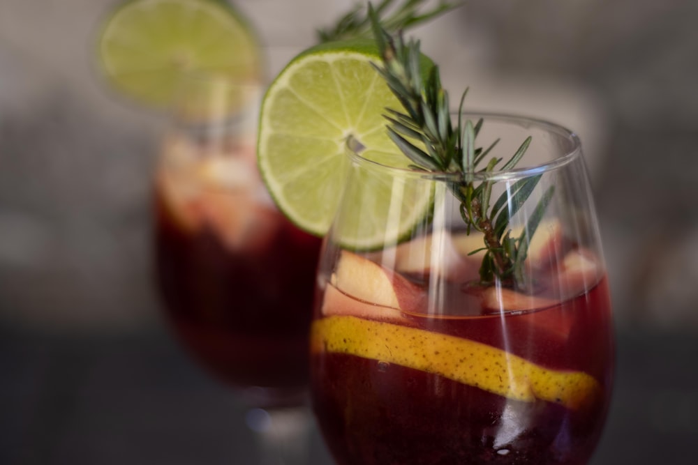 verre transparent avec liquide rouge et citron tranché