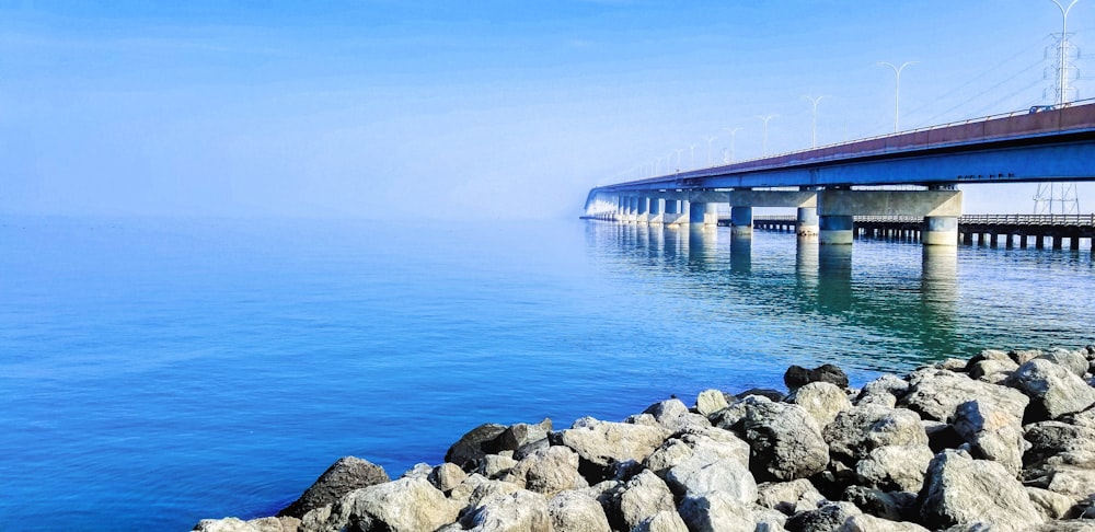 roches grises près du plan d’eau sous le ciel bleu pendant la journée