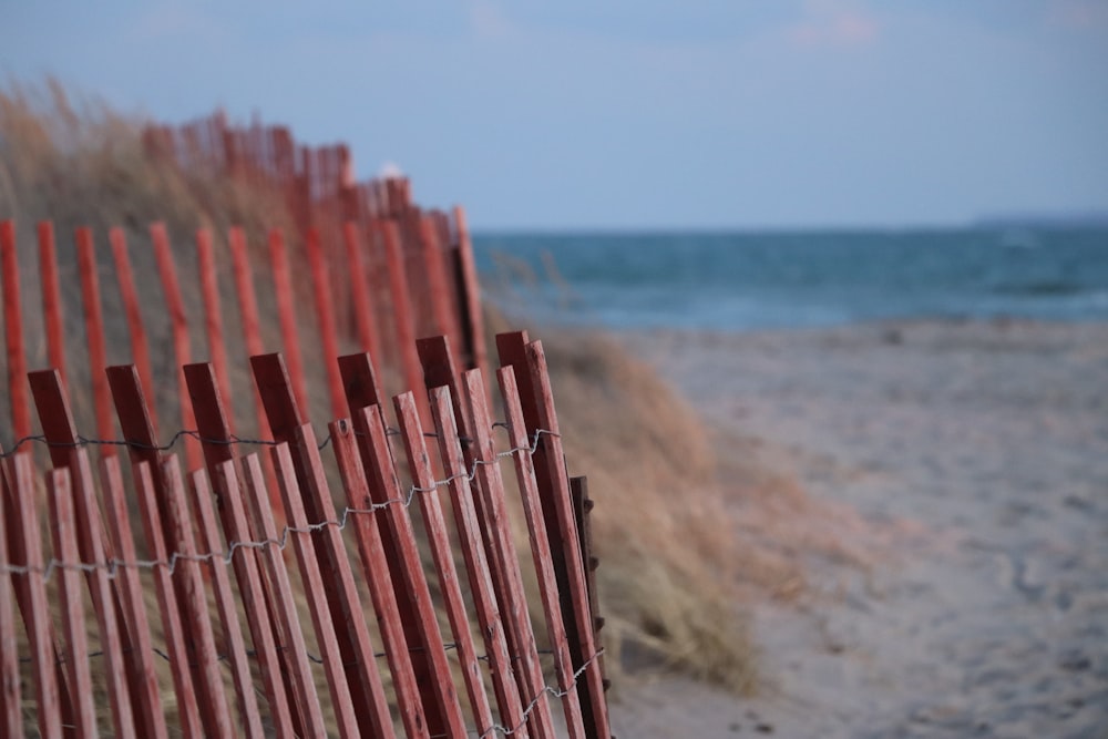 brown wooden fence near sea during daytime