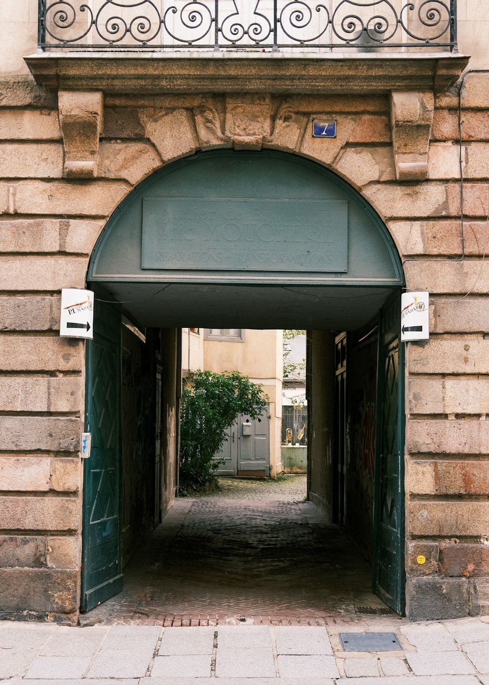 Bâtiment en brique brune avec porte en bois vert