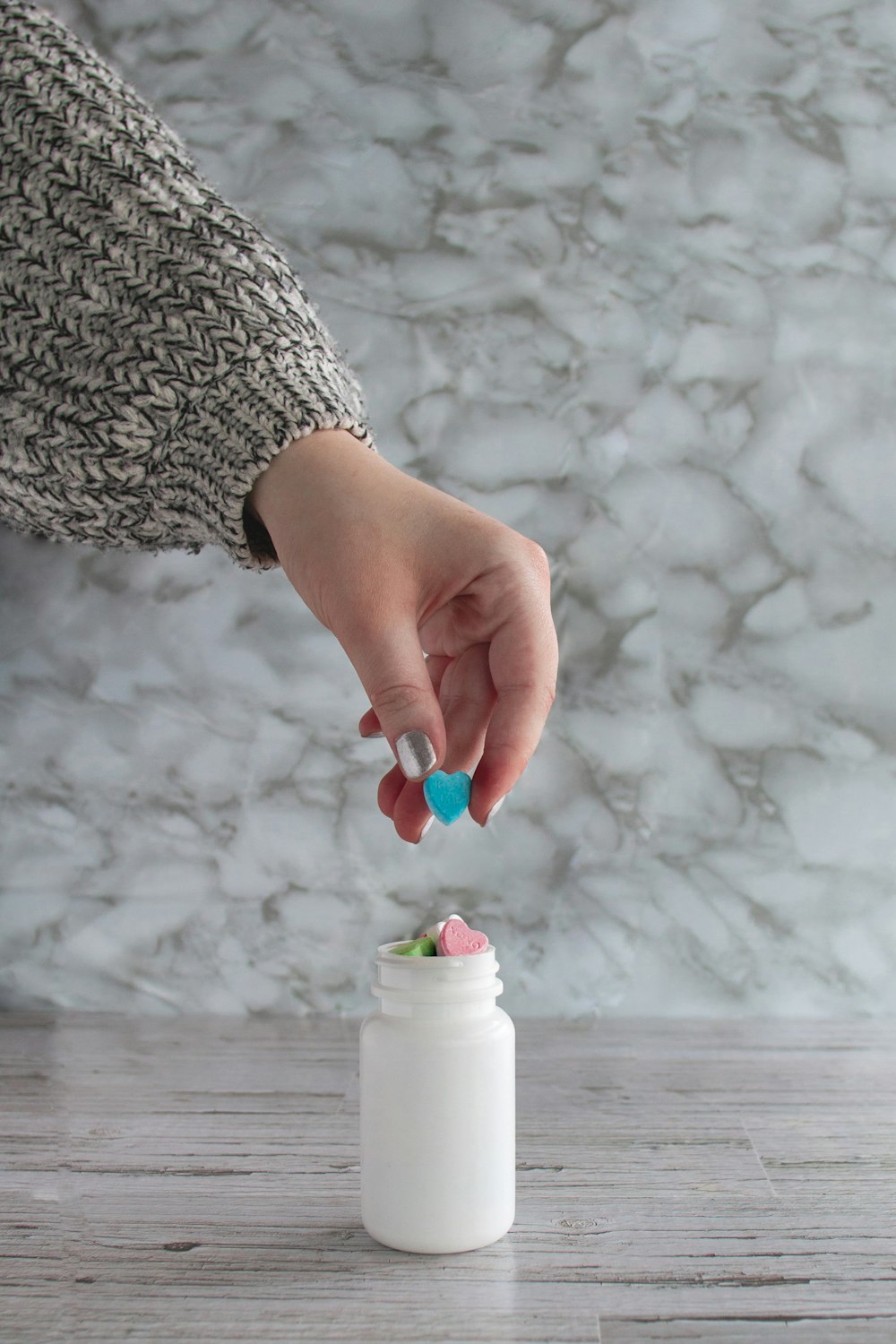 person holding white and pink plastic bottle