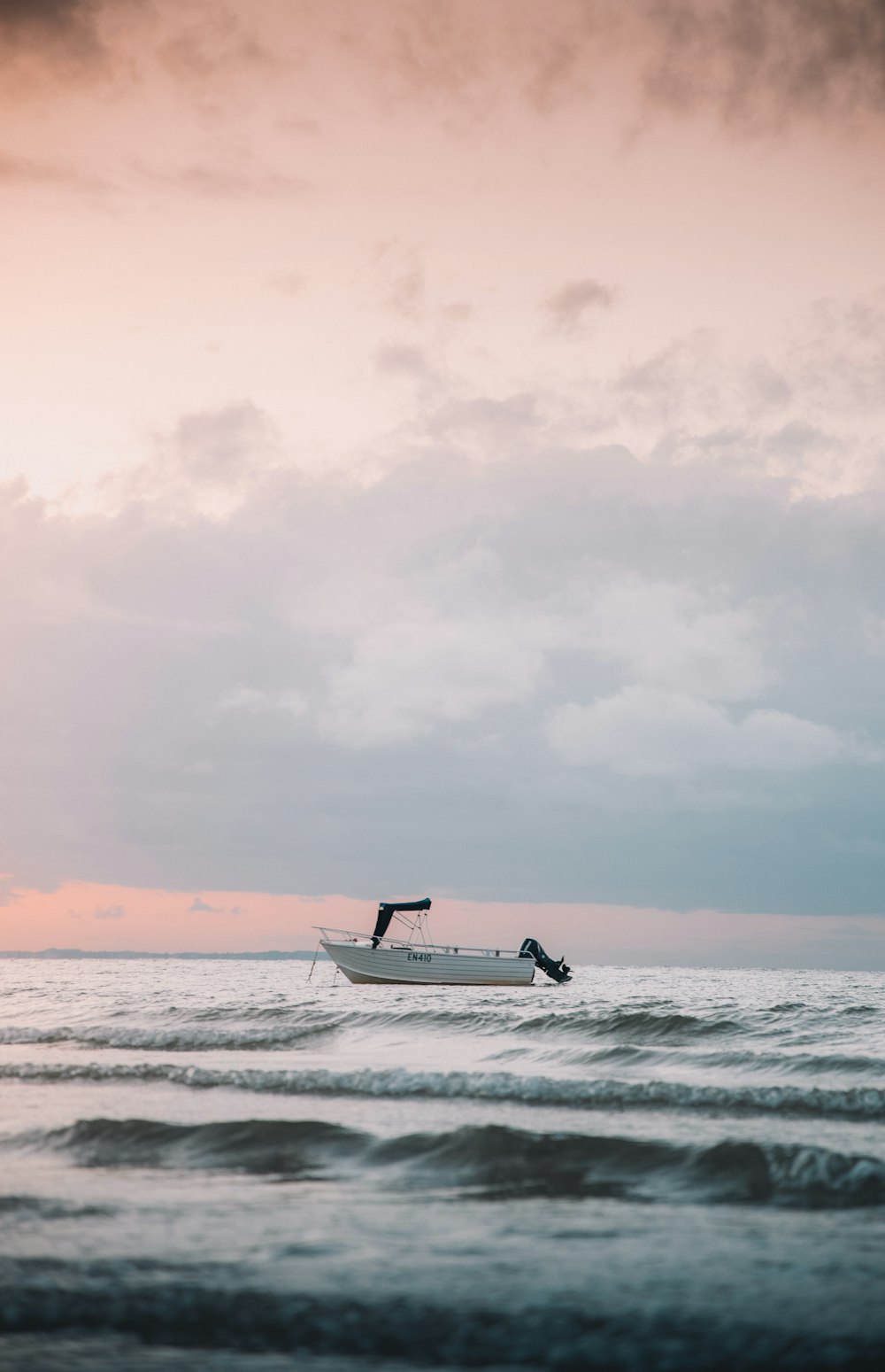 white and black boat on sea under white sky during daytime