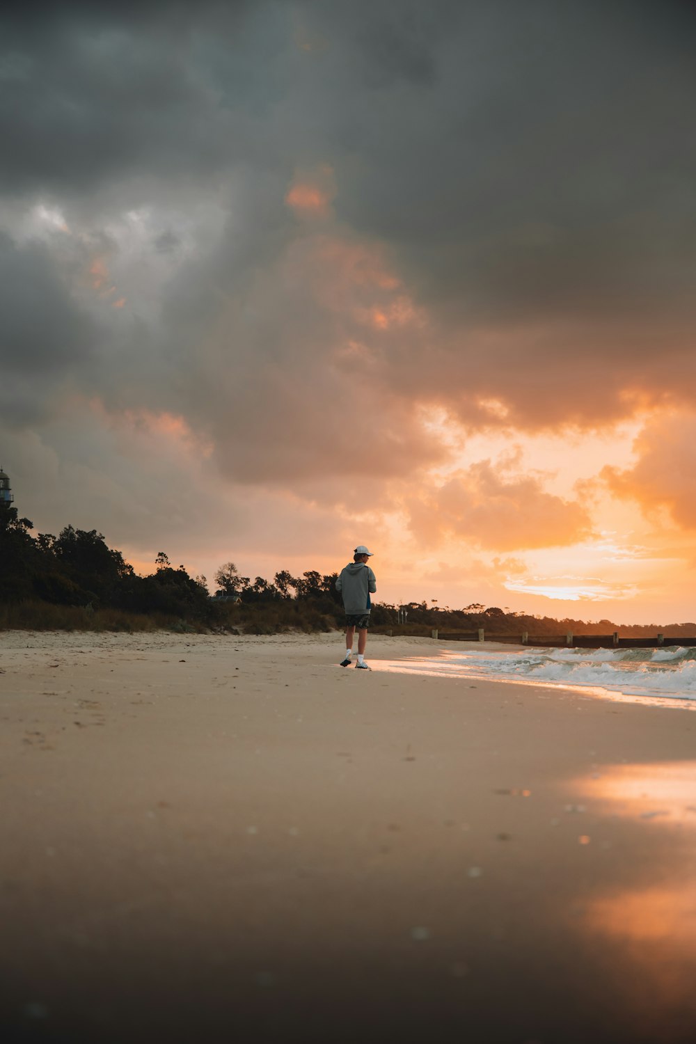 man and woman walking on beach during sunset