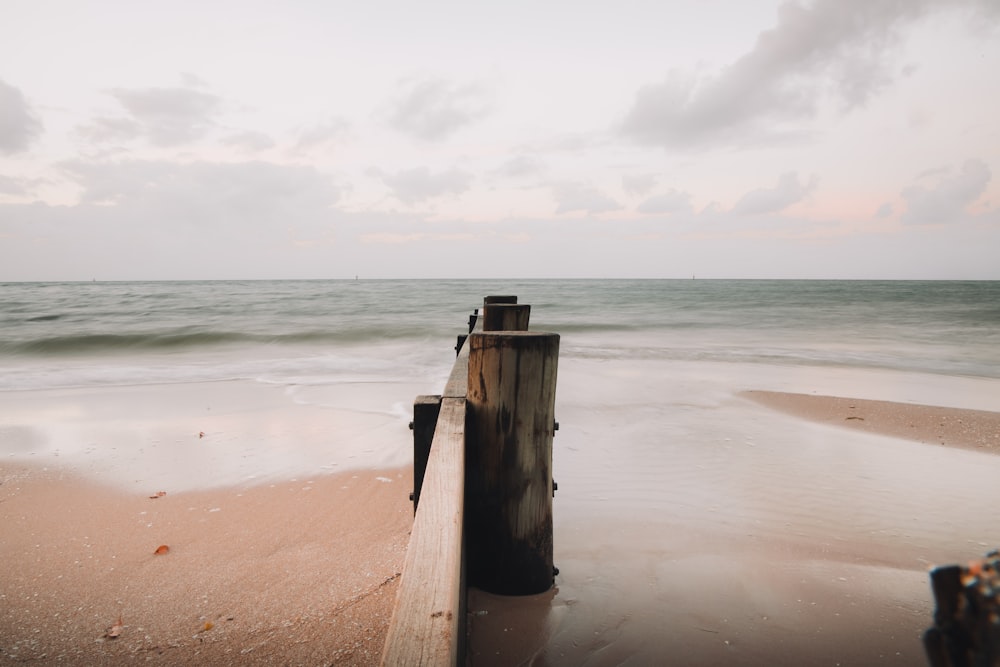 brown wooden post on beach during daytime