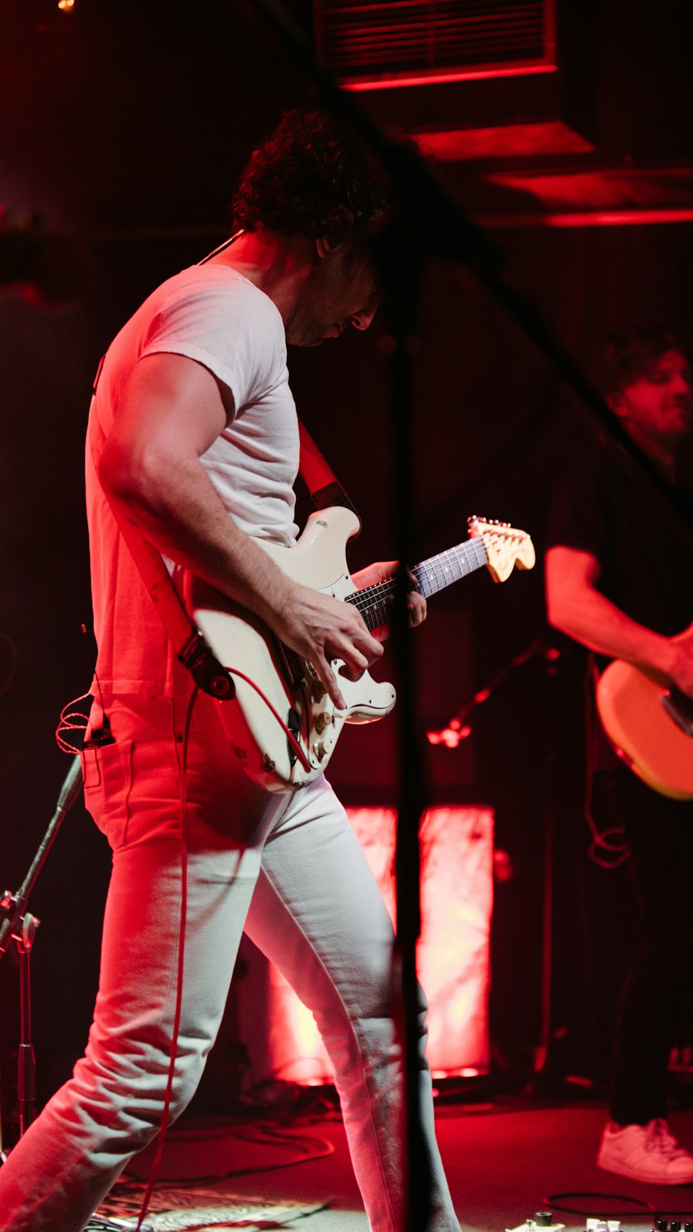 man in gray t-shirt playing electric guitar
