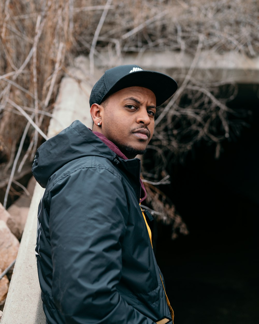 Hombre con chaqueta negra y gorra negra