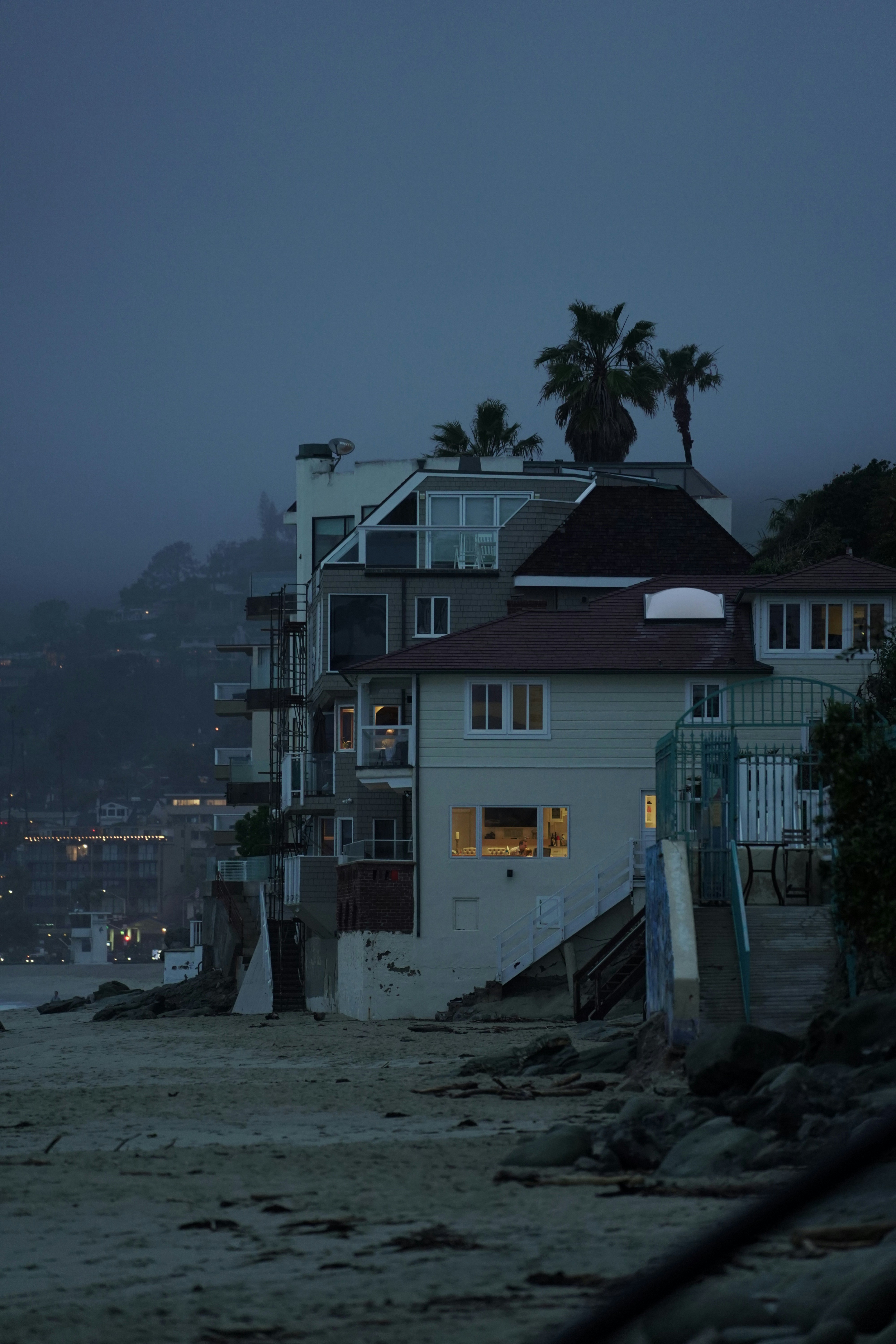 white and brown concrete house near body of water during daytime