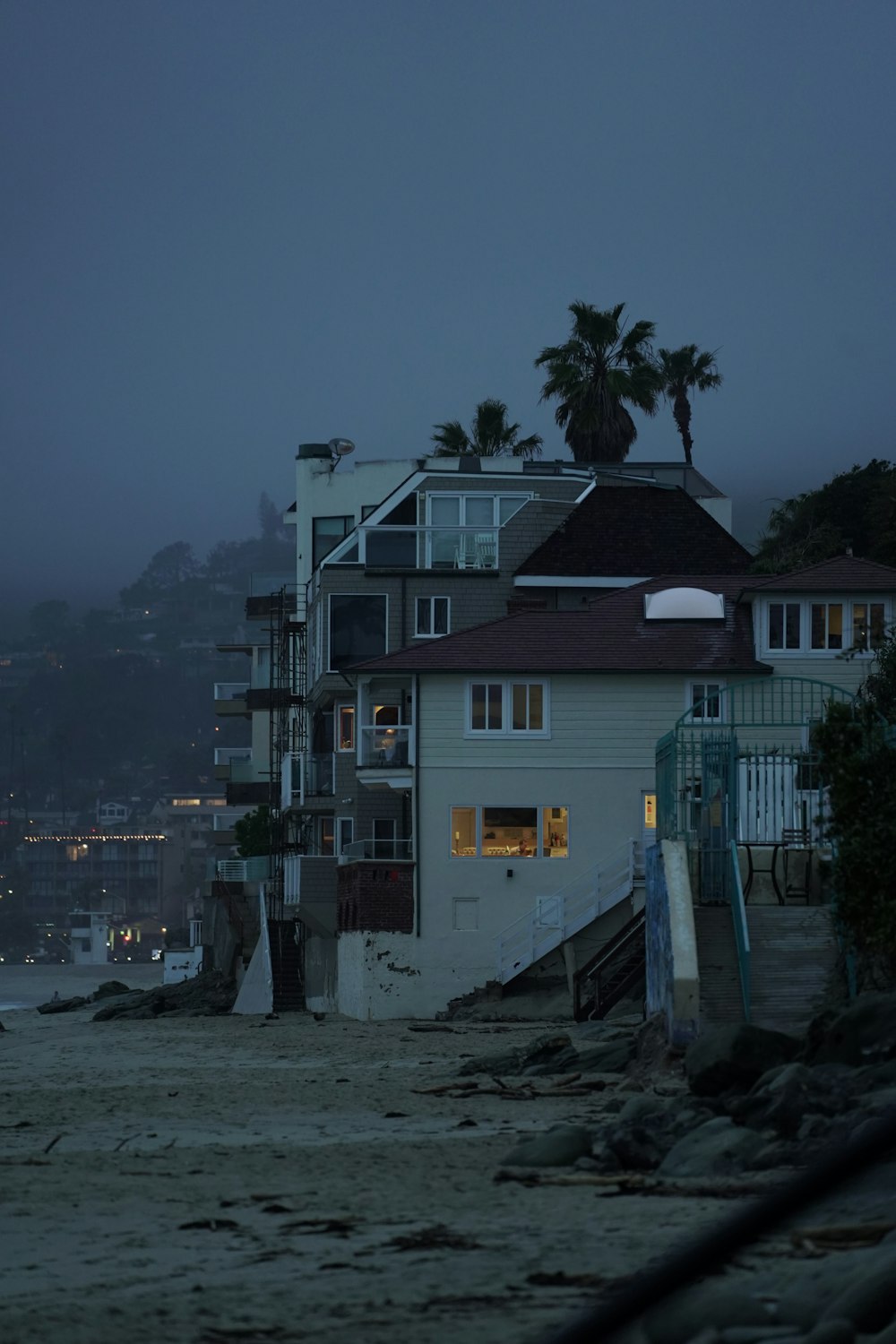 white and brown concrete house near body of water during daytime