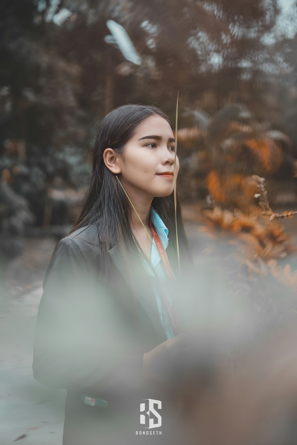 woman in white button up shirt holding stick with smoke