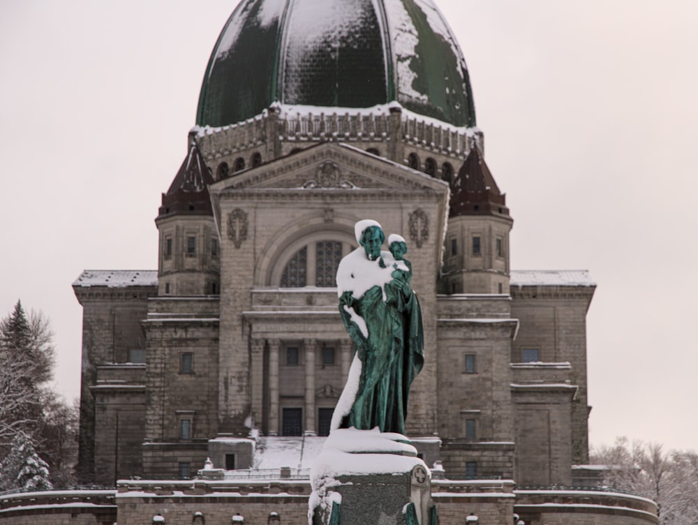 statue of man in front of brown concrete building