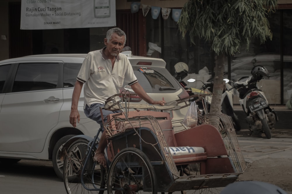 man in white button up shirt riding on red and black bicycle during daytime