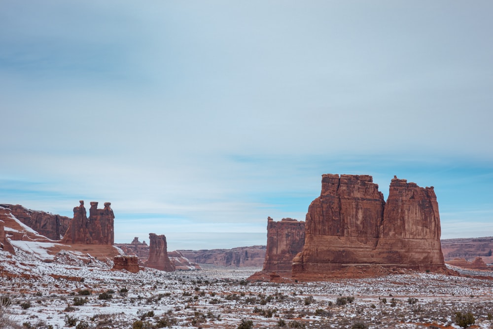 brown rock formation under white clouds during daytime