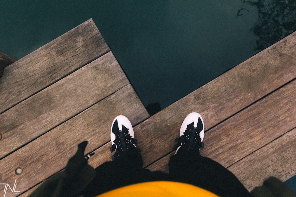 person in black pants and white sneakers