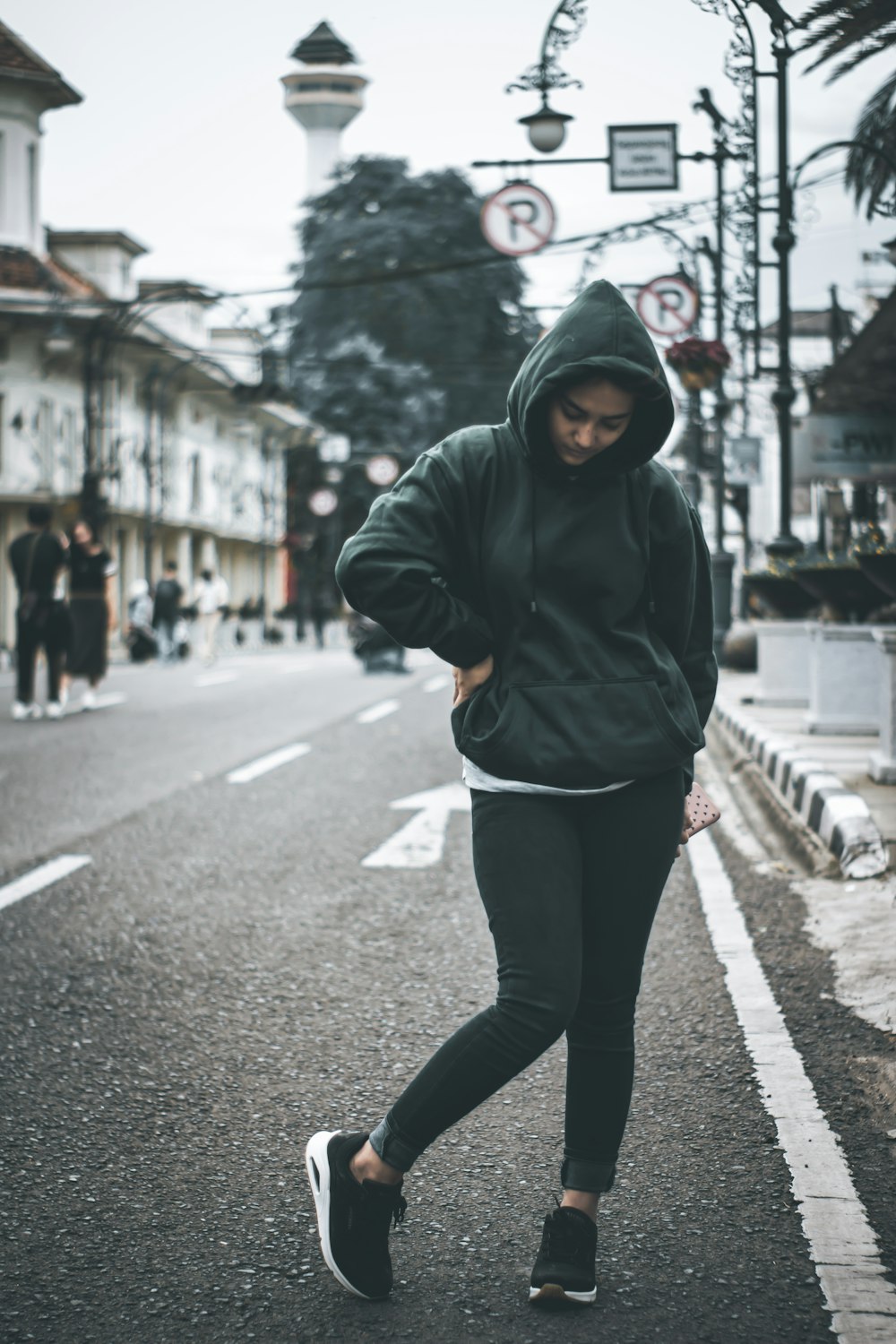 woman in black hoodie and black pants walking on street during daytime  photo – Free Grey Image on Unsplash