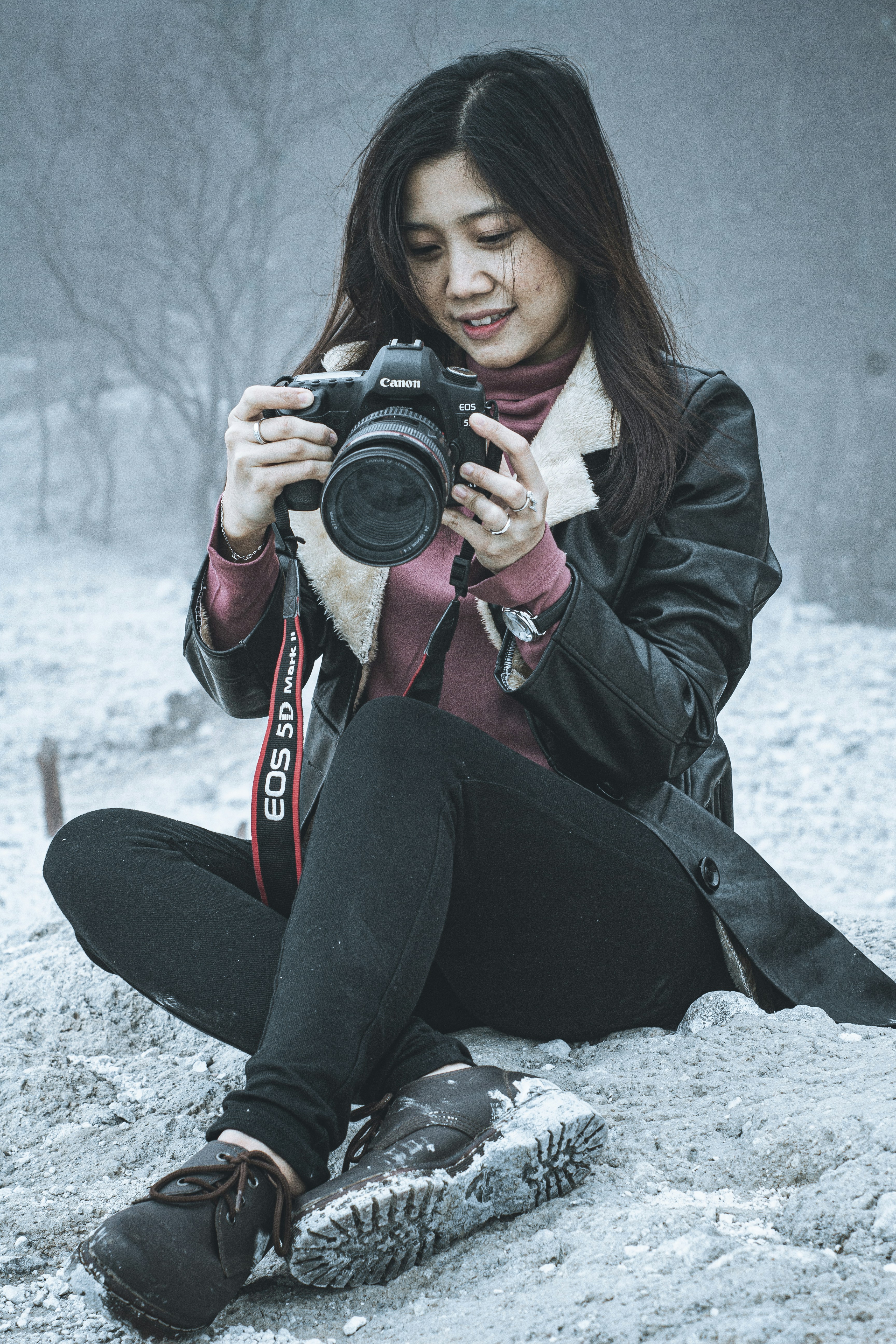 woman in black jacket and black pants holding black dslr camera