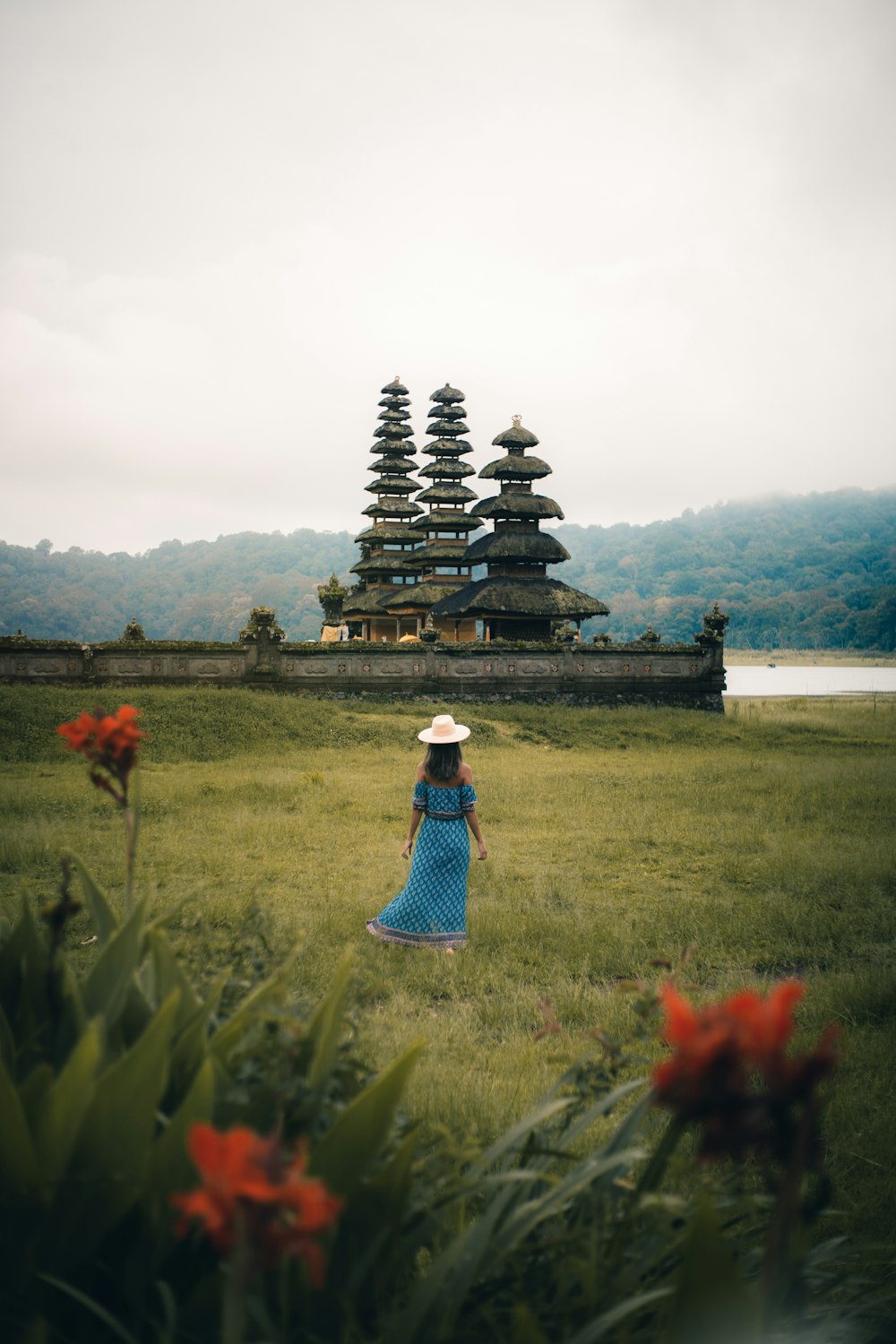 woman in blue and white dress standing on green grass field during daytime