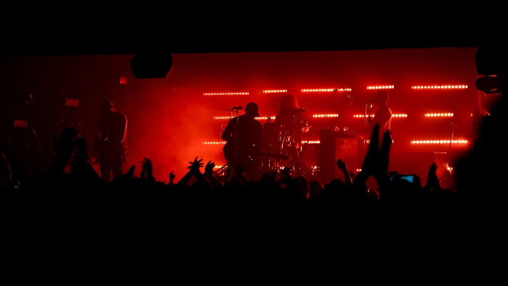 people standing on stage with red lights