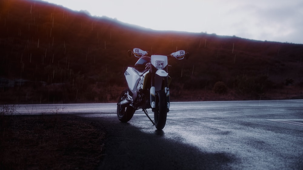 man in white shirt riding motorcycle on road during daytime