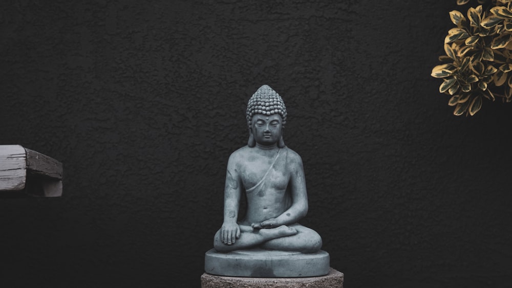 Statue de Bouddha en béton gris sur fond noir