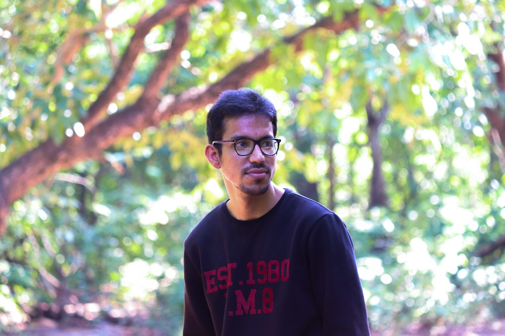 man in black crew neck shirt wearing black framed eyeglasses