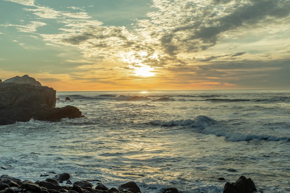 Les vagues de l’océan s’écrasent sur les rochers au coucher du soleil