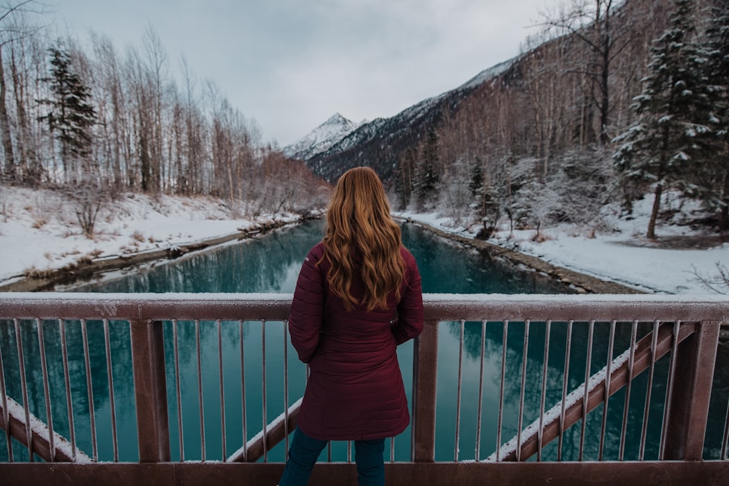 woman stands overlooking a large open lake